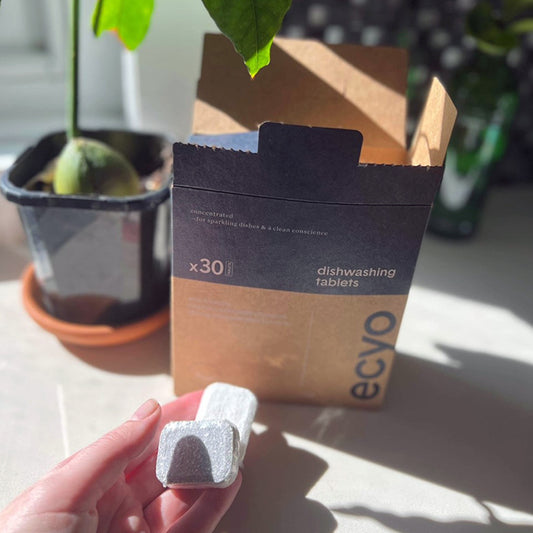 Two of the Ecyo Eco Dishwasher Tablets in front of cardboard box