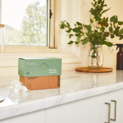 A box of Ecyo Eco Laundry Capsules scented with lemon myrtle and eucalyptus on a kitchen bench.