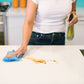 casual woman using multipurpose spray on kitchen counter using cleaning refill pods